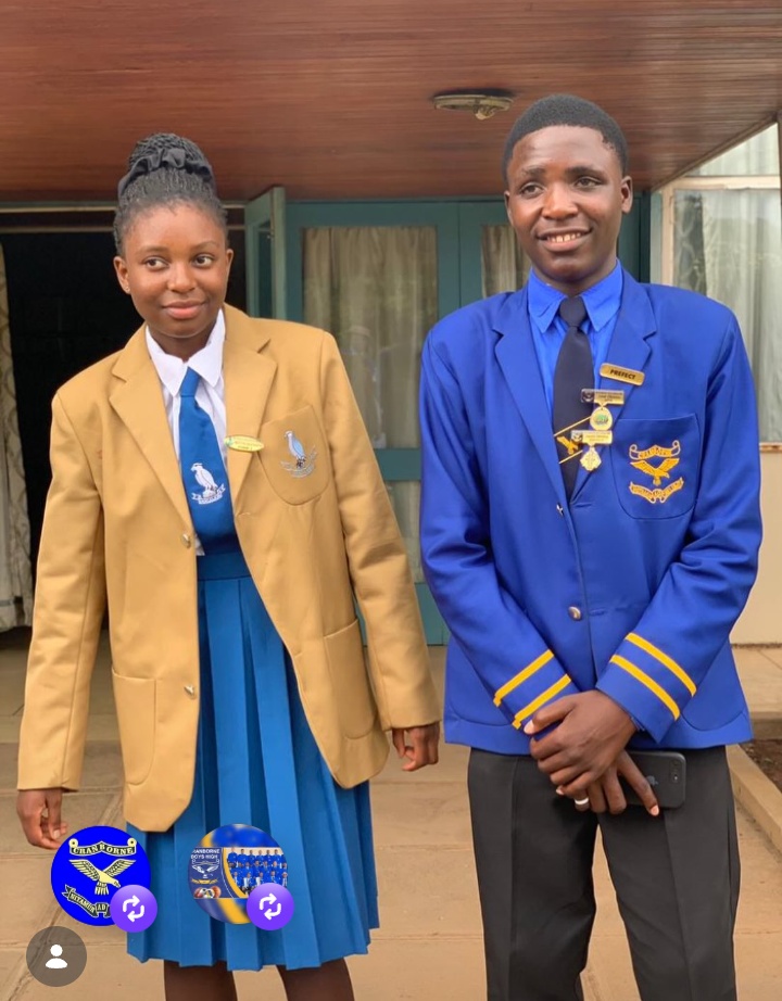 Two students in gold and blue school blazers standing together